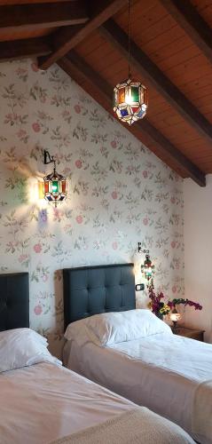 two beds in a bedroom with flowers on the wall at VILLA NABRISA MARBELLA, 5 BEDROOM, PRIVATE POOL, GARDEN, BBQ in Marbella