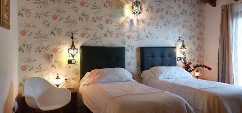 two beds in a bedroom with floral wallpaper at VILLA NABRISA MARBELLA, 5 BEDROOM, PRIVATE POOL, GARDEN, BBQ in Marbella