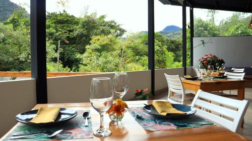 a dining room with a table with glasses and a view at Las Terrazas de Dana Boutique Lodge & Spa in Mindo