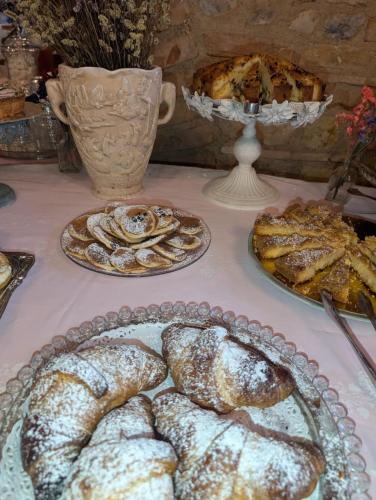 a table topped with plates of bread and pastries at Agriturismo le Fontanelle da Valente in Montichiari