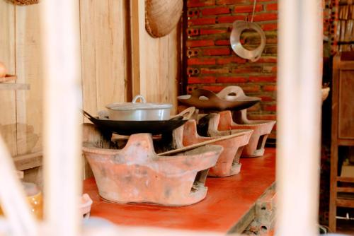 a row of pots and pans sitting on a table at Nhà lá Miền Tây Việt Nam 