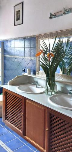 a bathroom with two sinks and a flower in a vase at VILLA NABRISA MARBELLA, 5 BEDROOM, PRIVATE POOL, GARDEN, BBQ in Marbella