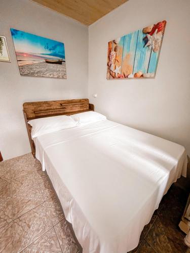 a bedroom with a large white bed in a room at Pousada Tia Maria in Ilha do Mel