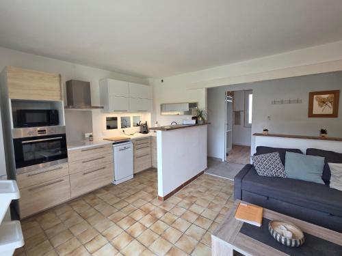 Il comprend une cuisine et un salon doté d'un canapé bleu. dans l'établissement Maison à Aix-en-Provence avec grand jardin, à Aix-en-Provence