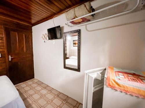 a bedroom with a mirror and a bed in a room at Pousada Tia Maria in Ilha do Mel