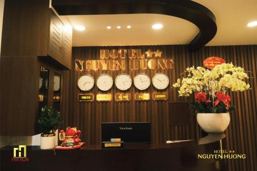 a room with clocks on a wall with flowers at Nguyên Hương Hotel in Ho Chi Minh City