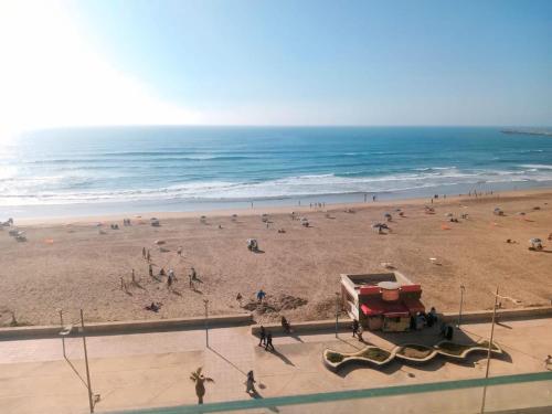 a group of people on a beach with the ocean at Appartement a La Perle de La plage de Mehdia Kenitra vue sur mer Excellent sea view in Plage de Mehdia
