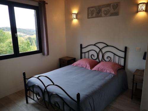 - une chambre avec un lit doté d'oreillers roses et d'une fenêtre dans l'établissement Le chalet de fayolle, à Montrem