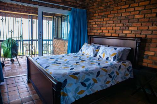 una cama en una habitación con una pared de ladrillo en Ikhthus Accommodation N, en Hibberdene