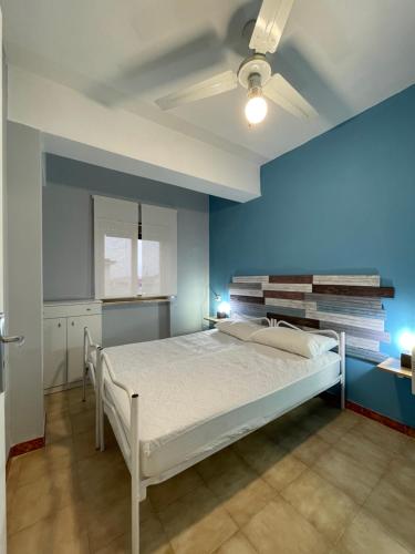 a bedroom with a bed with a blue wall at Appartamento VITARI in Roseto Capo Spulico