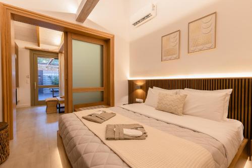 a bedroom with a large bed with towels on it at Zoella Earth Suites in Preveza