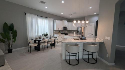 a kitchen and living room with a counter and a table at Spacious 5 BD Luxury Getaway Near Westgate in Glendale