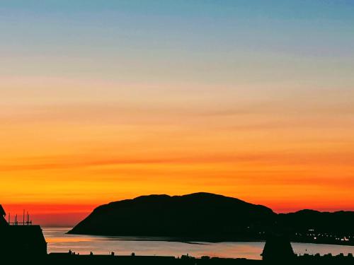a silhouette of a mountain against a sunset at Bron Orme Private Hotel in Llandudno