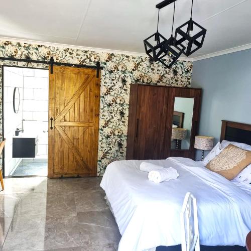 a bedroom with a bed and a wooden door at Victorian Villa Westdene Benoni in Benoni