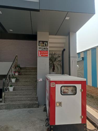 a red and white machine sitting in front of a building at Hotel Mehra Inn in Haldwāni