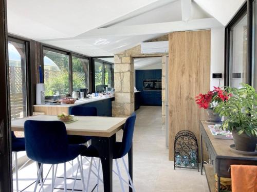 une cuisine avec une table en bois et des chaises bleues dans l'établissement Domaine La Buissière Duravel 