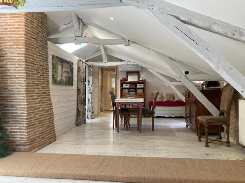 an attic room with a table and chairs in it at Domaine La Buissière Duravel "La Maison" Piscine privative in Duravel