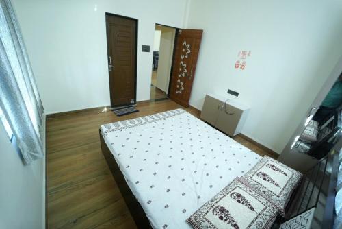 a small bedroom with a bed and a doorway at Kashid Farmhouse junnar in Junnar