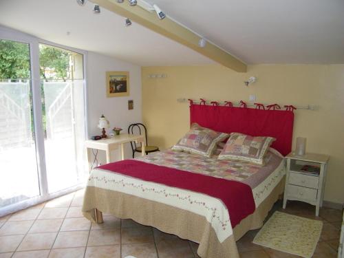 GalarguesにあるDomaine du bois gîte Marionのベッドルーム1室(赤いヘッドボード付きのベッド1台付)