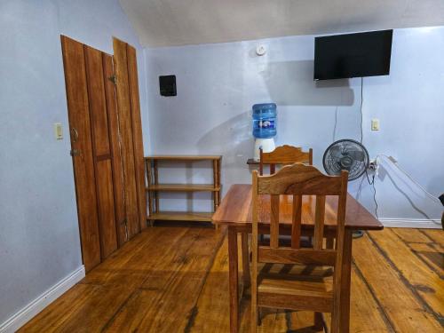 a dining room with a table and a television at Cotton Tree Cabin at Freshwater Creek Cabanas in Hopkins