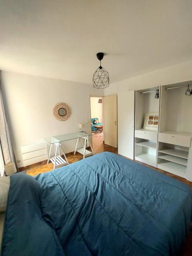 - un grand lit bleu dans une chambre avec une table dans l'établissement Appartement Les Lavandes, T2 avec terrasse, aux Lecques