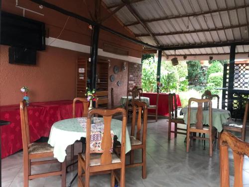 a dining room with tables and chairs and a television at Gorilla African Guest House in Entebbe