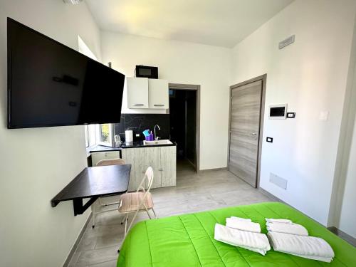 a bedroom with a green bed and a kitchen at Santa Marinella Homes in Santa Marinella