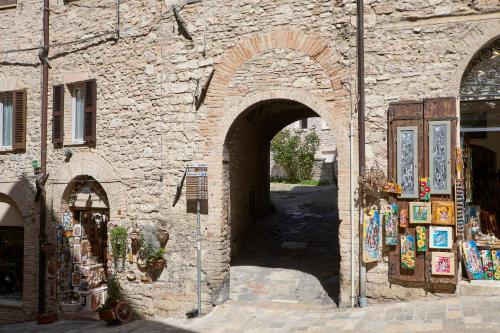a stone building with an archway in a street at Il Cortile di San Rufino in Assisi