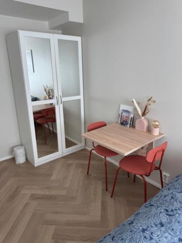 Habitación con mesa, sillas y espejo. en Short stay in the city center with free parking, en Tampere