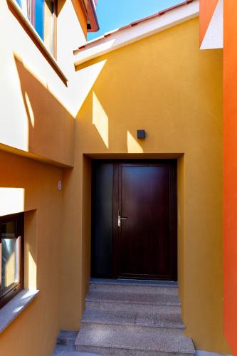 a building with a brown door and stairs at Casinha da Avó Ana in Sever do Vouga
