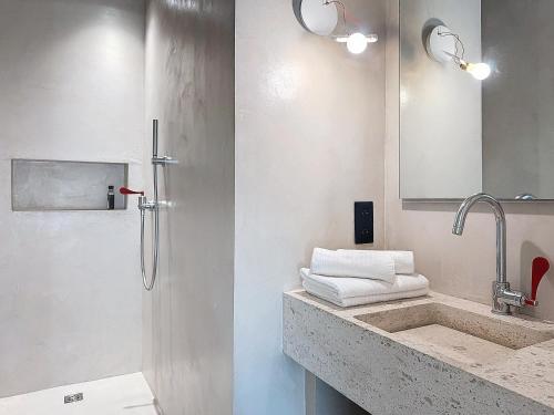 a bathroom with a sink and a shower with towels at Villas Inamorata in Lecci