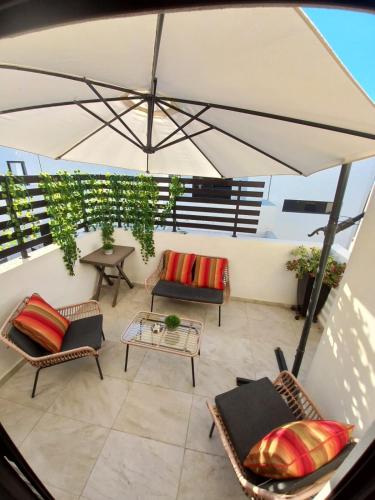 patio esterno con sedie e ombrellone di Beautiful new house with pool club a Los Bledales