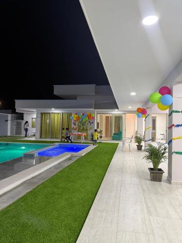 a room with a swimming pool and green grass at Sun Beach in Puerto Colombia