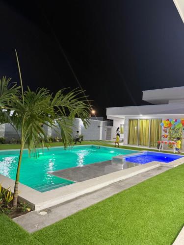 a swimming pool in front of a house at night at Sun Beach in Puerto Colombia