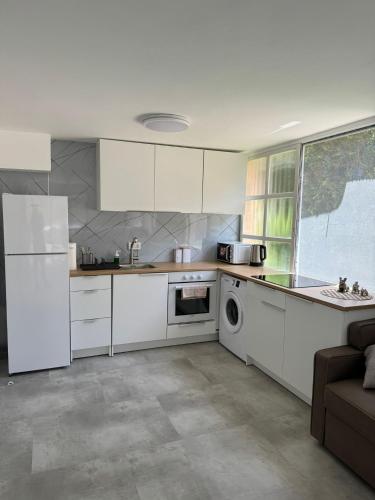 a kitchen with white appliances and a couch in it at Квартира in Nahariyya