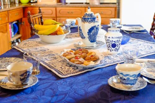 a table with a blue and white table cloth with food on it at A Casa do Olival - Barragem Castelo do Bode-Tomar in Barreira Grande