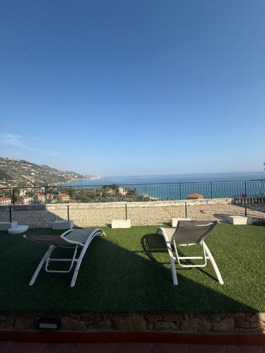 two chairs sitting on top of a field of grass at Agriturismo Un Mare di Fiori in Ventimiglia