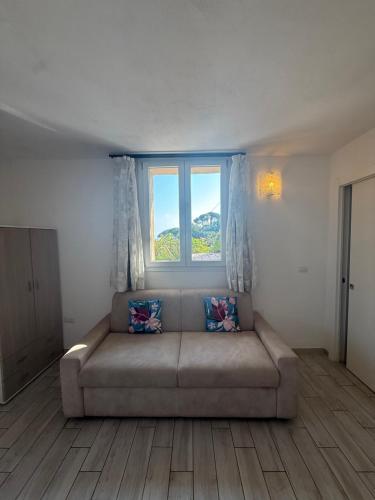 a living room with a couch and a window at Agriturismo Un Mare di Fiori in Ventimiglia