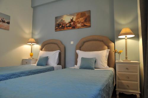 カテリオスにあるApartments Valta Viewのベッドルーム1室(ベッド2台、青いシーツ、ランプ2つ付)