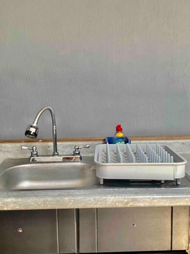 a kitchen sink with a dish drying rack next to it at Apartment10 minutes APTGDL in Guadalajara