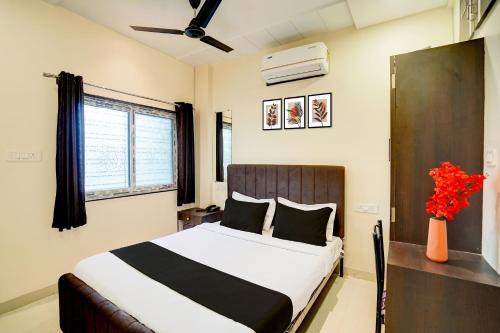 a bedroom with a bed and a vase of flowers at Super Hotel O Manish Nagar in Nagpur