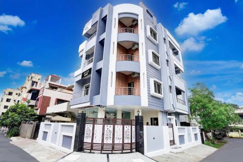 a tall white building with a gate at Super Hotel O Manish Nagar in Nagpur