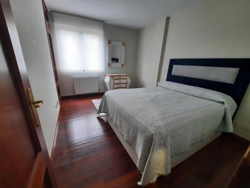 a small bedroom with a bed and a window at El Gallo Azul in Oruña