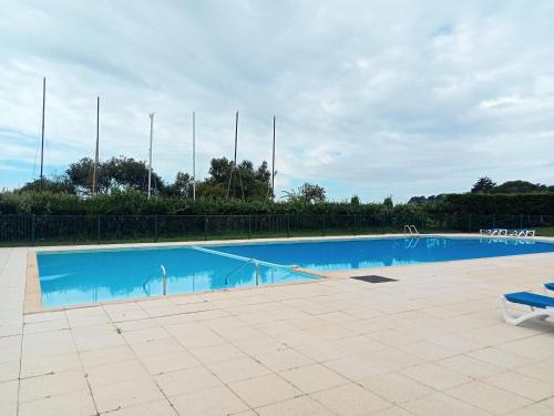 a large swimming pool with a blue pool at Appartement Arzon 4 - 5 PERSONNES , tout à pied, mer - port du crouesty - piscine in Arzon