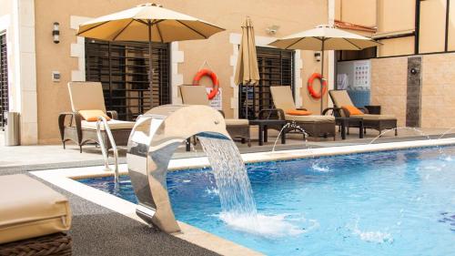 a pool with a water fountain in a hotel at LeRose Villa in Ash Shāghūr
