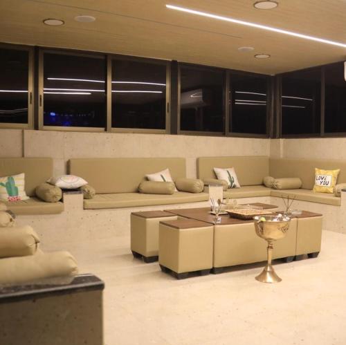 a living room with couches and a table at LeRose Villa in Ash Shāghūr