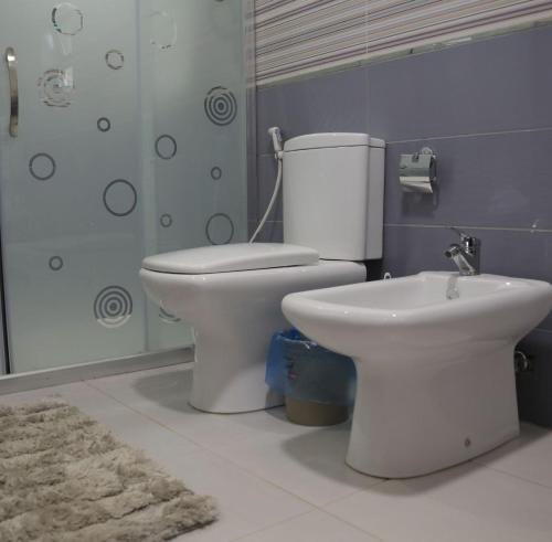 a bathroom with a toilet and a sink at LeRose Villa in Ash Shāghūr