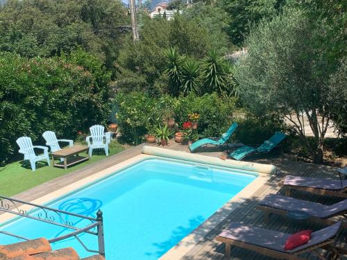 une piscine avec deux chaises et une table dans l'établissement Villa Provence Azur - Grand appartement avec piscine proche Méditerranée, à La Seyne-sur-Mer