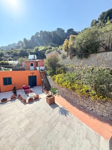 a house with a patio and a stone wall at Agriturismo Un Mare di Fiori in Ventimiglia