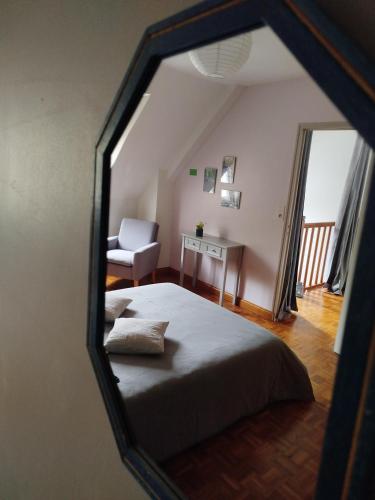 a view of a bedroom with a bed and a chair at Les Colibris in Tréhorenteuc